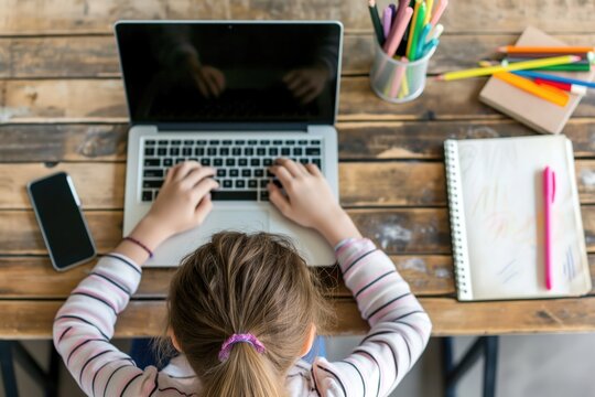 A young girl concentrates on her work, her fingers dancing across the keyboard of a laptop, surrounded by the tools of learning and creativity - Powered by Adobe