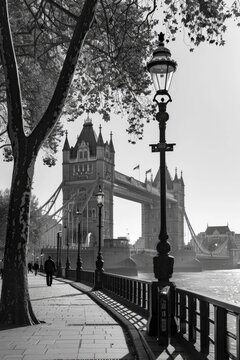 Fototapeta Black and White Photo of Tower Bridge in London with a Lamppost and Pedestrian