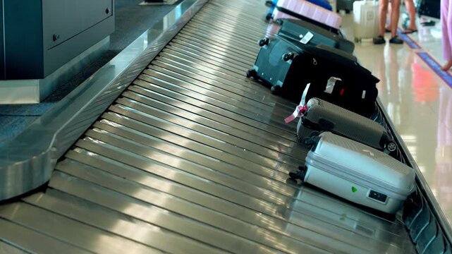 Suitcases move on a baggage carousel at the airport. Suitcases moving along the baggage conveyor belt in the arrival area of the passenger terminal of the international airport.