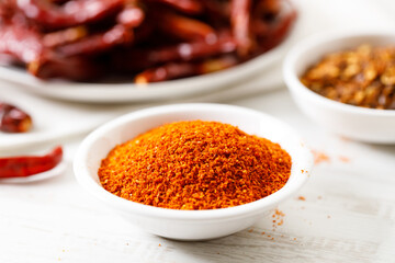 Dried red chilies on white wooden table.