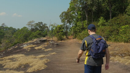 Man Hiking on Trail Through Forest, Exploring Nature and Enjoying Outdoors. Outdoor Adventure and Recreation.