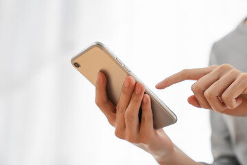 Woman holding a smartphone and using social media on internet.