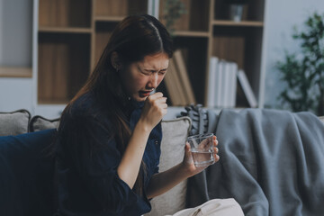 A woman with a cold with pills is treated at home chooses which drugs to take and self-medicates, checks the expiration date while sitting on the couch at home