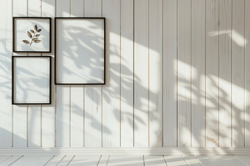 3 black picture frames on white wall, white wooden paneling, sunlight and shadows, minimalistic...