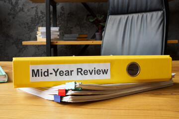 Stack of papers and folder with mid-year review.