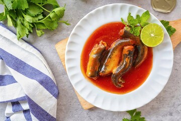Sardines in tomaro sauce ,canned fish,Tinned fish in a white plate, top view food table