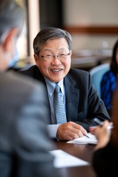 Portrait of an Asian philanthropist meeting with beneficiaries of a grant, Generative AI