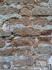 Fototapeta premium patterns of red bricks of and old abandoned church tower wall.Medieval gothic church reamins in central Europe