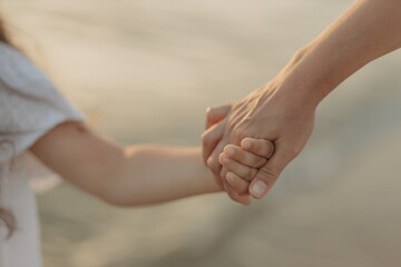 Mom and daughter's hands in close-up.  