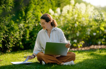 woman working on laptop in summer morning