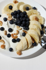 Greek Yoghurt with Fresh Blueberries, Cashew Nuts, Banana. Homemade Breakfast.