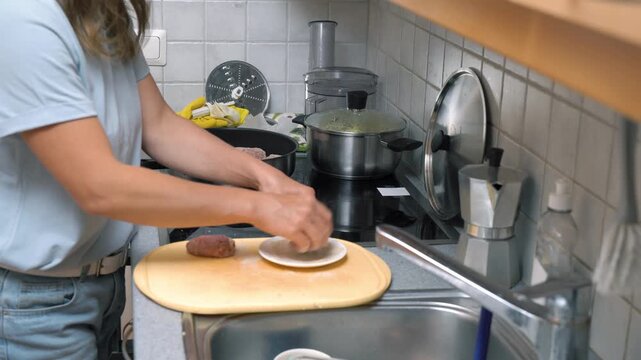 Woman cooking meatballs or meat patties cutlets frying with oil in a pan on the stove. Home cooking, traditional recipes and culinary