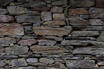 Weathered stone wall architectural detail. Ancient historical stone wall. Stone structure background texture for design and montage purposes.