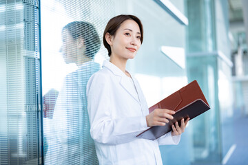 病院内に立つ白衣を着た女性