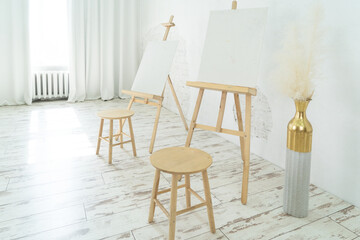 This bright art studio features a large table, a comfy chair, and colorful artwork, fostering creativity