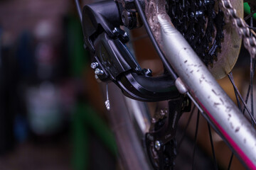 Obraz premium Mountain bike repair and maintenance. The rear derailleur is a close-up on a black background.