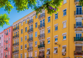 Fototapeta premium Yellow facade with large windows and balconies. Lisbon, Portugal