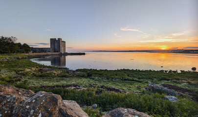 Beautiful coastal sunset scenery with historical landmark Oranmore castle at Galway bay, Ireland,...