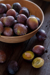Fruit background, organic fruits. Still life food. Basket of fresh blue plums on a stone table.