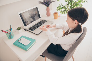 Photo portrait of cute small schoolgirl sit table netbook online lesson answer count math fingers home education concept school interior