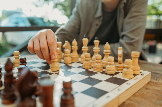 Hand of teenage boy holding chess piece