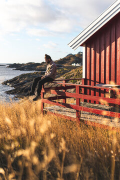 Man sitting on edge of railing at Lofoten and Vesteral Islands