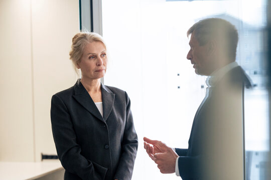 Senior business colleagues discussing with each other at office