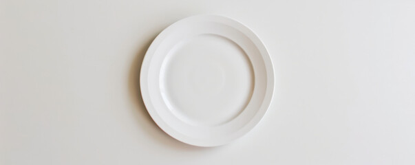Festive concept featuring a blank white plate on a white table, viewed from above. The clean white theme signifies purity. Plenty of room for text.