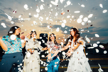 Cheerful friends celebrating together and having fun with confetti