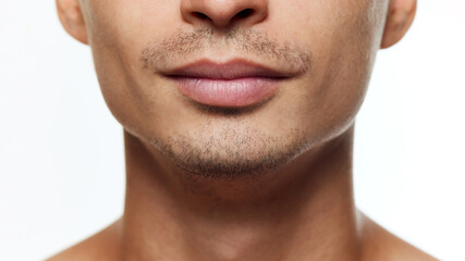 Obraz premium Close-up photo of male face, full lips against white studio background. Man with well-kept, healthy and lifted skin. Concept of beauty, facial-care, cosmetology treatment, wellness, masculinity. Ad