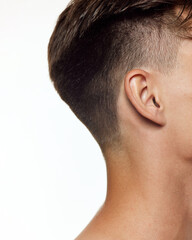 Obraz premium Cropped photo of man's head focusing on neatly trimmed side and back of his hair, highlighting precision of haircut against white studio background. Concept of beauty, care, wellness, masculinity. Ad