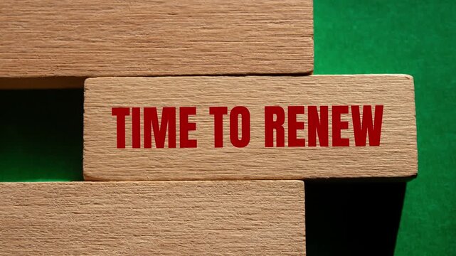 Time to renew message writing on wooden block on green background