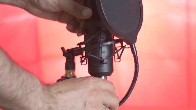 An audio technician turns off a professional microphone. Disconnecting the cable from the socket.