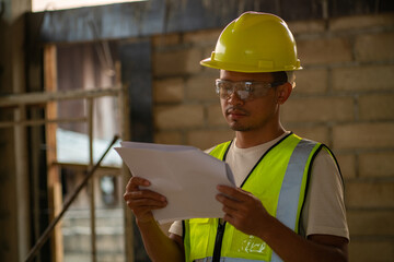 Foreman inspector working interior modern house building with blueprint plan