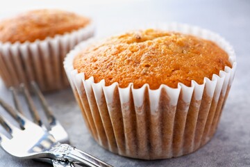 Banana cup cake with fork on light cement background 