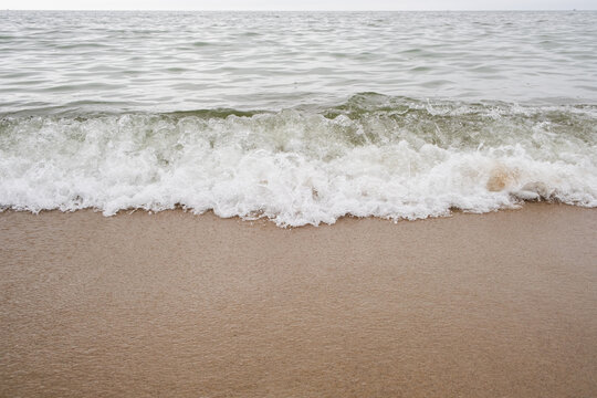 Waves of the sea on the sandy beach. Beautiful natural background.