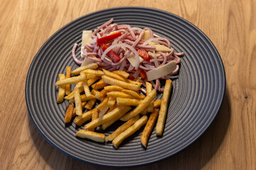 a plate of fresh sausage salad and french fries