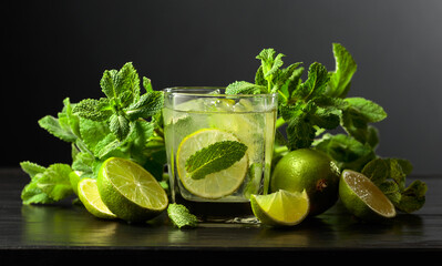 Mojito with ice, lime, and mint on a black background.