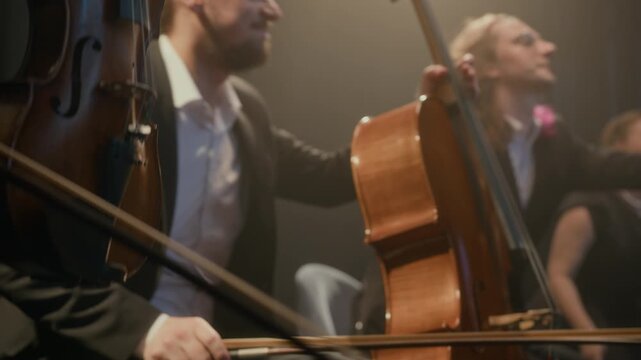PAN shot of professional music quartet of string players in black suits and dresses bowing after performance