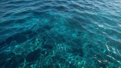Obraz premium Crystal clear teal water with sunlight reflections.