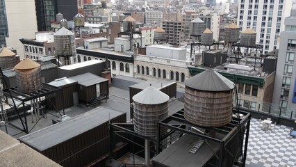New York City Manhattan cityscape. Rooftop water towers from view point in USA, residential buildings roof tanks. Real Estate, urban architecture, United States streets. Midtown Chelsea district, NYC.