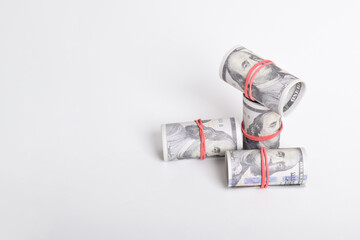 Bundle of money roll of dollars isolated on white background. One hundred dollar American cash rolled with red rubber. U.S. dollars. $100 bills