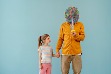 Daughter looking at father with mask of chaotic thoughts using smart phone