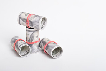 Bundle of money roll of dollars isolated on white background. One hundred dollar American cash rolled with red rubber. U.S. dollars. $100 bills