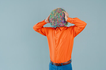 Frustrated man with mask of chaotic thoughts against blue background