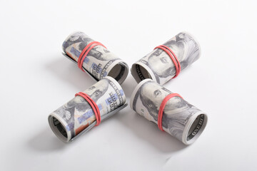 Bundle of money roll of dollars isolated on white background. One hundred dollar American cash rolled with red rubber. U.S. dollars. $100 bills