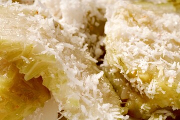 Lupis is a traditional Indonesian sweet snack made from glutinous rice, topped with grated coconut and drizzled with palm sugar syrup.