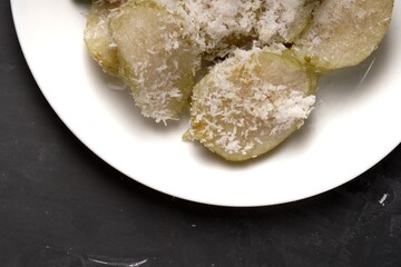 Lupis is a traditional Indonesian sweet snack made from glutinous rice, topped with grated coconut and drizzled with palm sugar syrup.