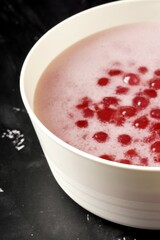 A bowl of Monte, a sweet Indonesian porridge with small, chewy red pearls served in savory coconut milk
