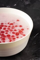 A bowl of Monte, a sweet Indonesian porridge with small, chewy red pearls served in savory coconut milk